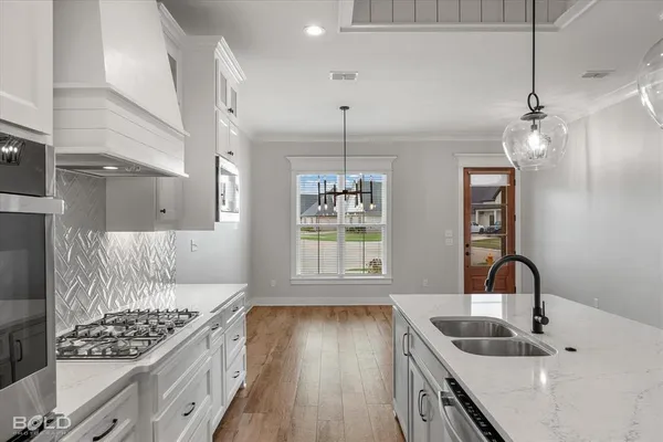 a kitchen with kitchen island a sink stainless steel appliances and cabinets