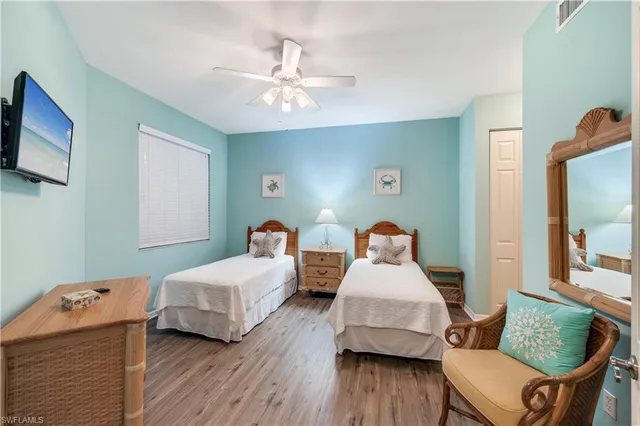 a bedroom with two beds and wooden floor