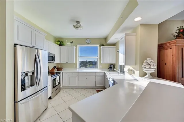 a large kitchen with a large window and stainless steel appliances