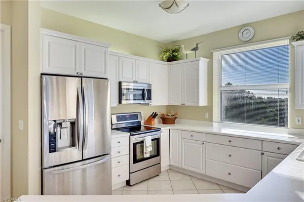a kitchen with white cabinets and stainless steel appliances