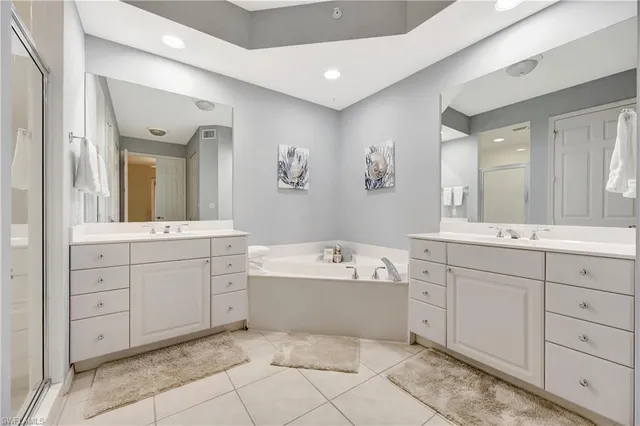 a spacious bathroom with a tub sink and mirror