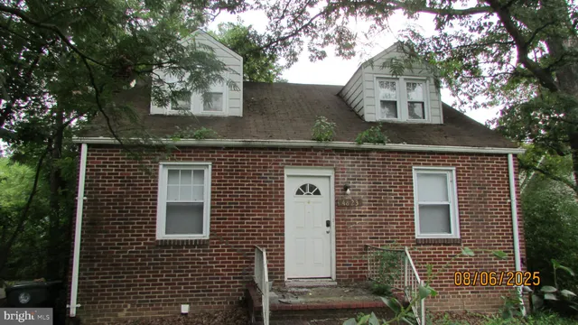 a front view of a house with a tree