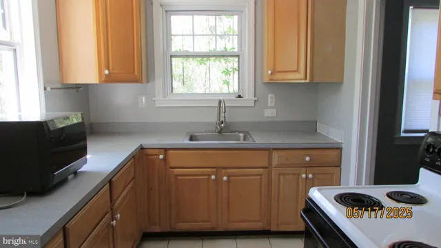 a kitchen with granite countertop a sink a stove and cabinets