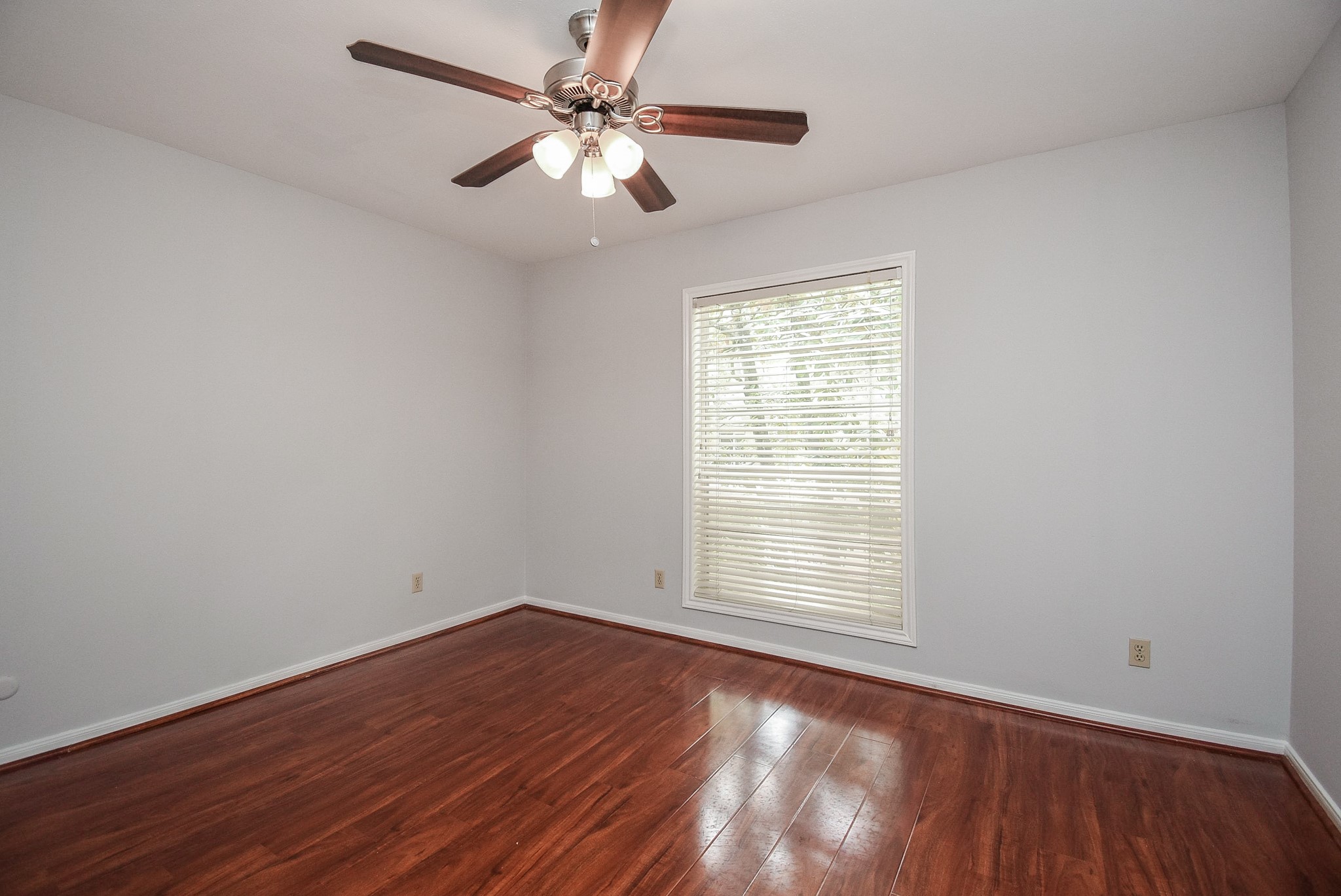 201 Vanderpool Lane, Unit 113 Houston, TX 77024 - Photo 33 of 45 an empty room with wooden floor fan and windows