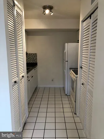 a view of a refrigerator in kitchen and utility room