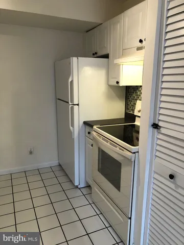 a kitchen with white cabinets and white appliances