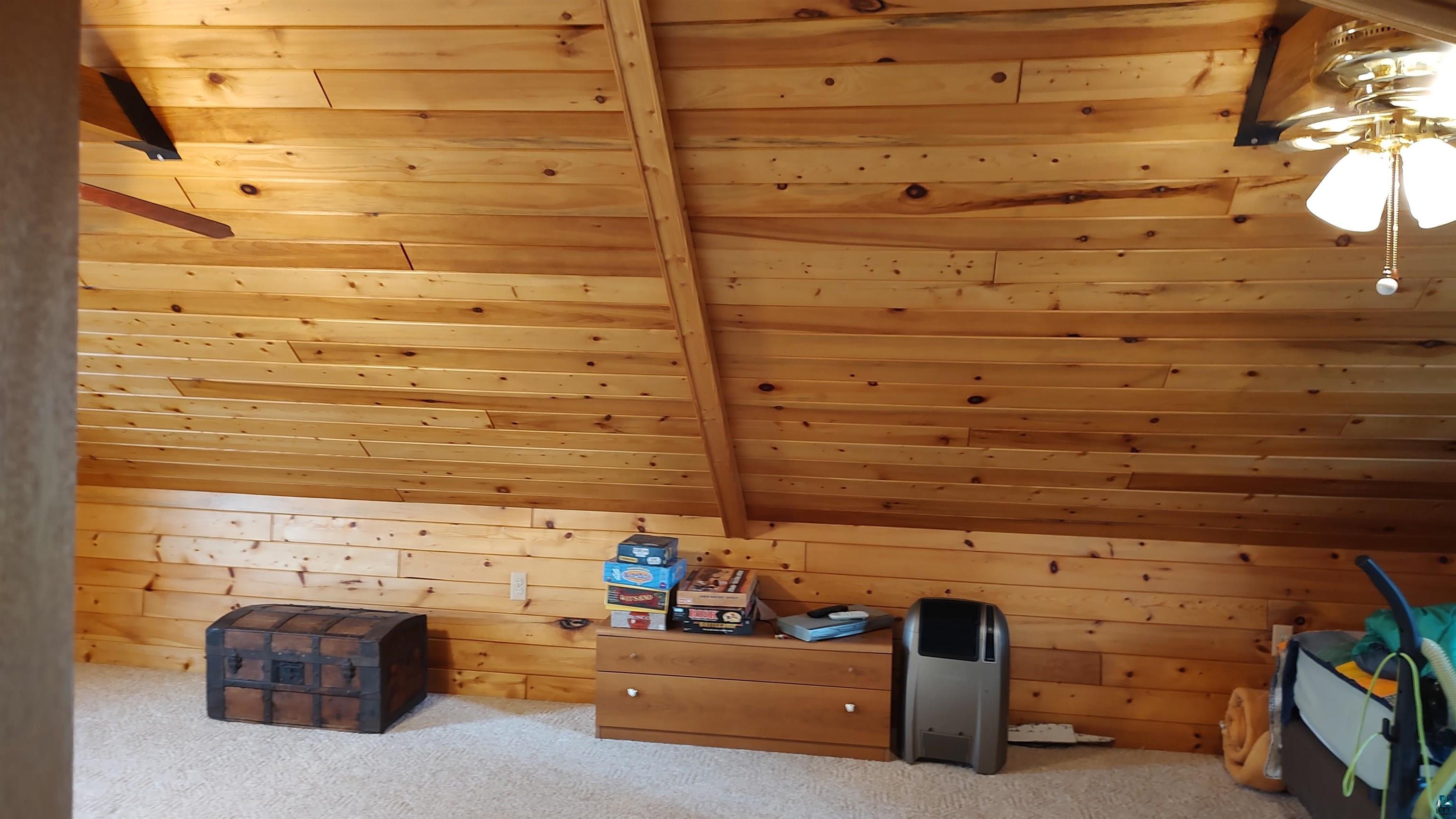 2585 Hautala Road Iron River, WI 54847 - Photo 16 of 28 Sloped wood-paneled ceiling with exposed beams and wood-paneled walls