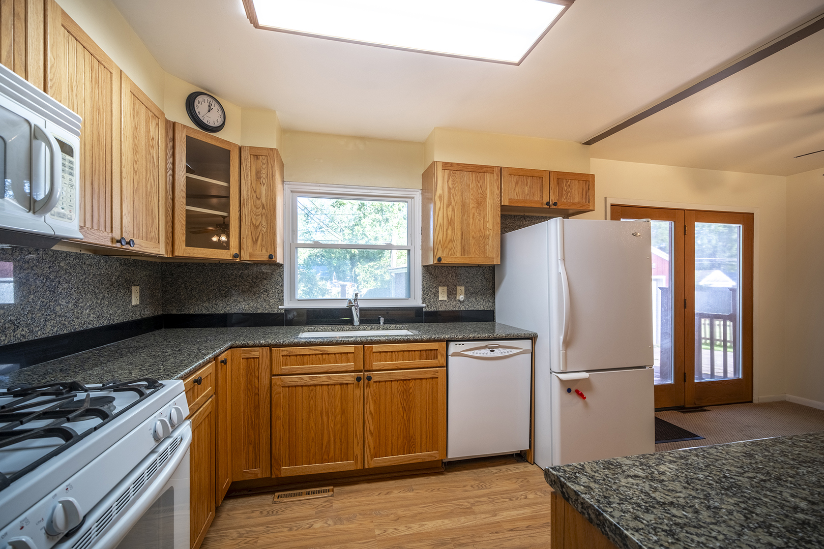 47 Briarcliff Road Montgomery, IL 60538 - Photo 5 of 19 a kitchen with stainless steel appliances granite countertop a refrigerator a sink dishwasher a stove and a dining table with wooden floor