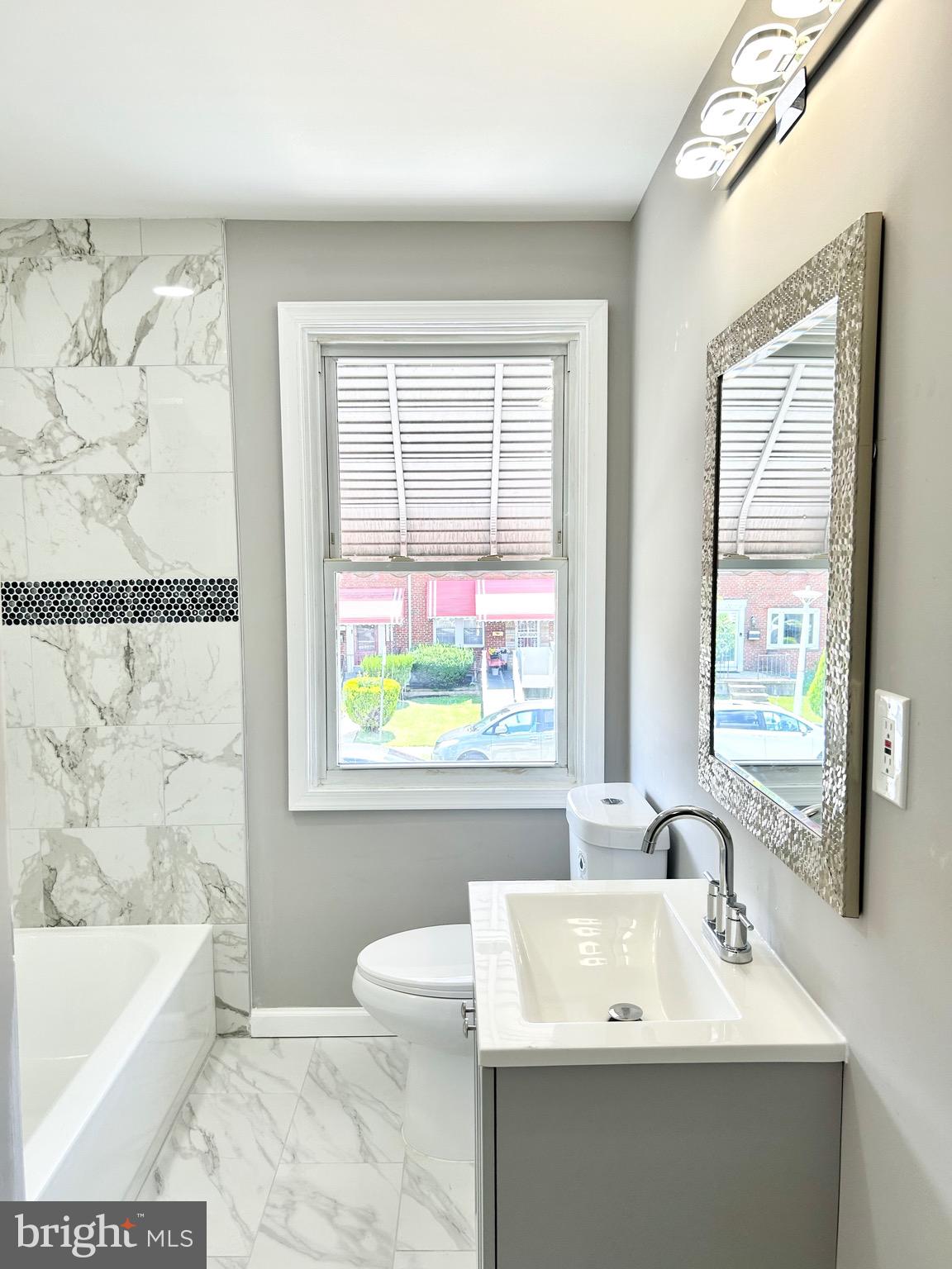 3506 Elmora Avenue Baltimore, MD 21213 - Photo 13 of 27 a bathroom with a sink a bathtub and a window
