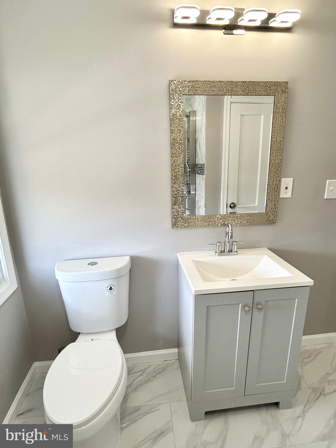 3506 Elmora Avenue Baltimore, MD 21213 - Photo 14 of 27 a bathroom with a toilet sink and mirror