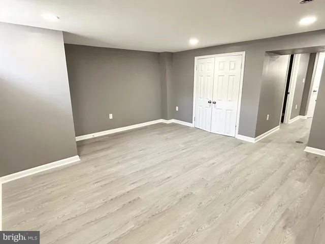 an empty room with wooden floor and mirror