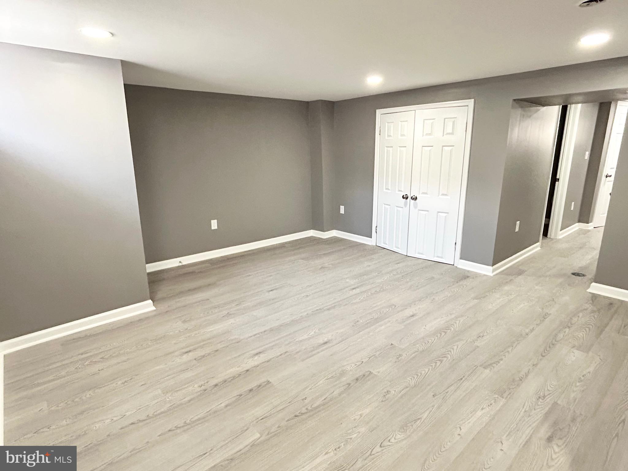 3506 Elmora Avenue Baltimore, MD 21213 - Photo 19 of 27 an empty room with wooden floor and mirror