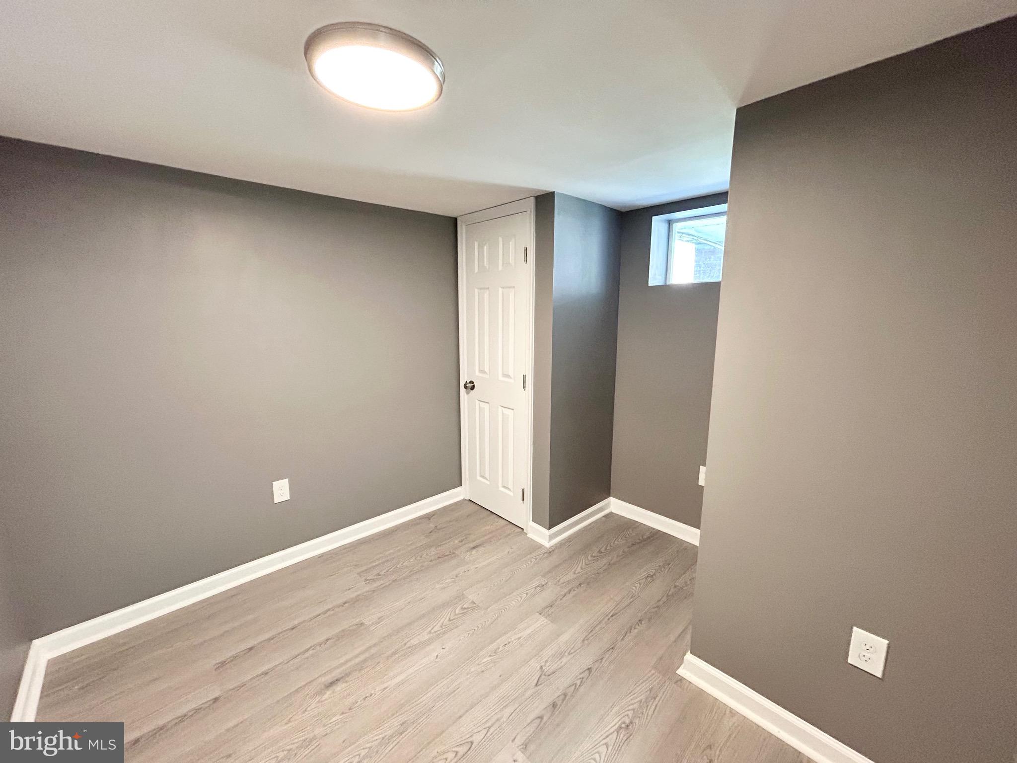 3506 Elmora Avenue Baltimore, MD 21213 - Photo 22 of 27 an empty room with wooden floor and windows