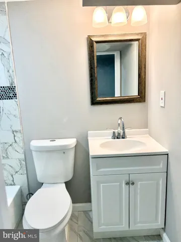 a bathroom with a toilet sink and mirror