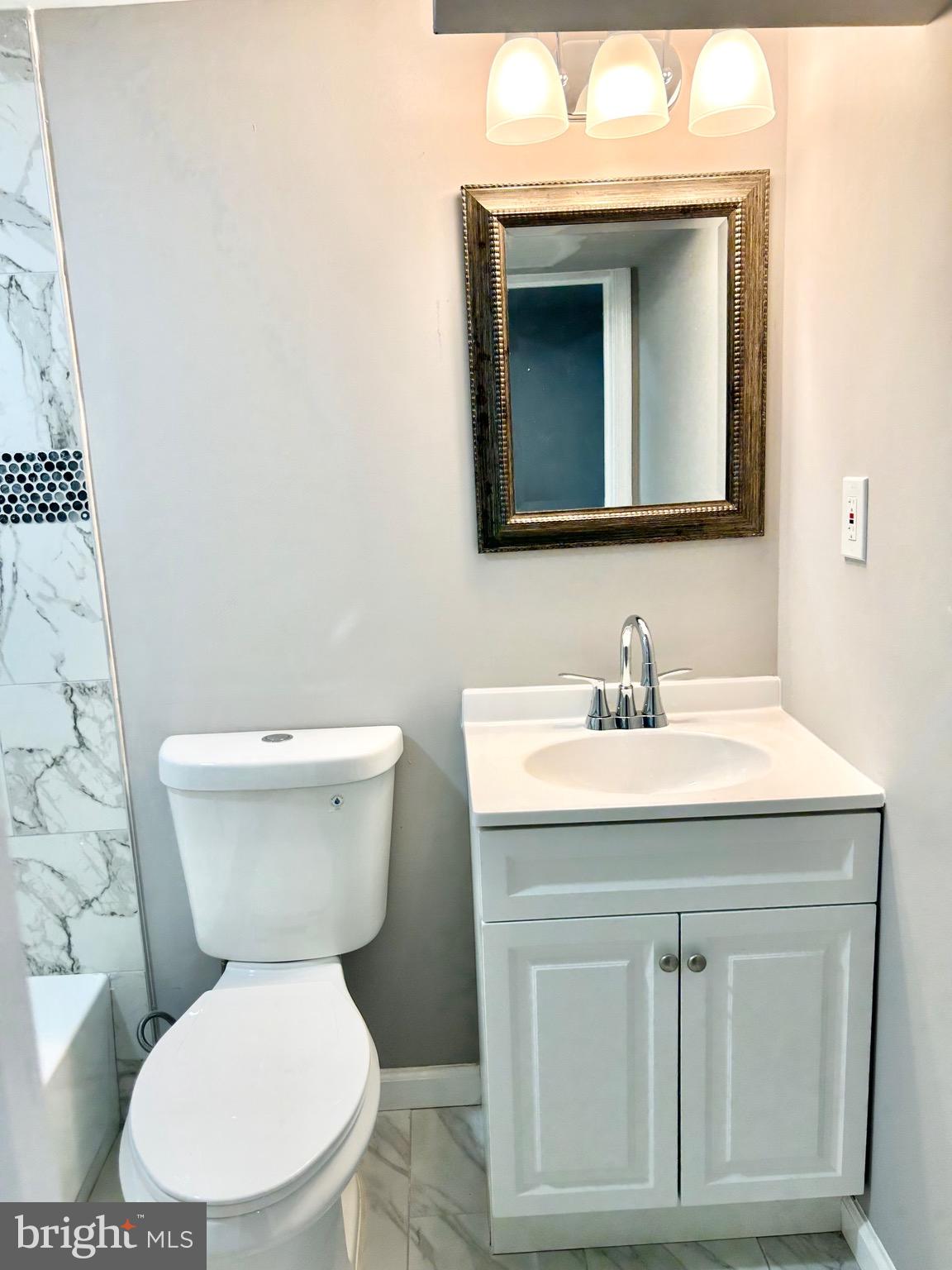 3506 Elmora Avenue Baltimore, MD 21213 - Photo 23 of 27 a bathroom with a toilet sink and mirror