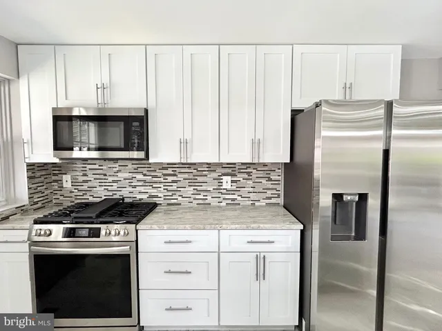 a kitchen with white cabinets and stainless steel appliances