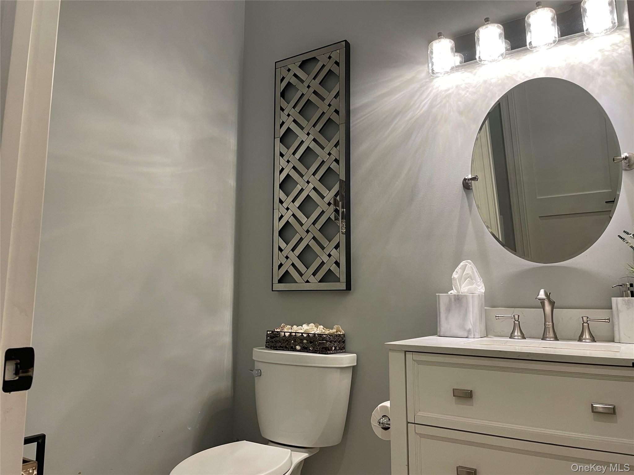 99 Spinney Road East Quogue, NY 11942 - Photo 14 of 40 a bathroom with a sink mirror vanity and toilet