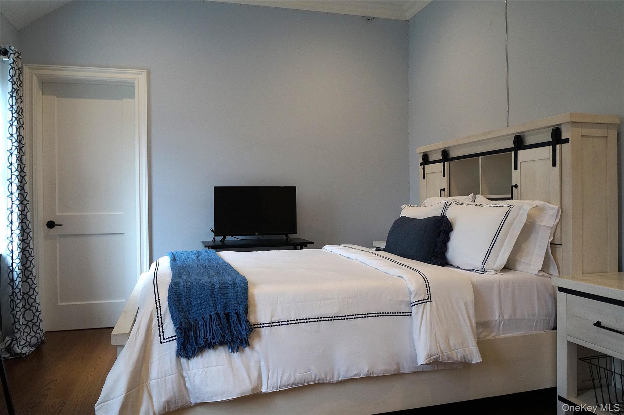 99 Spinney Road East Quogue, NY 11942 - Photo 24 of 40 a bedroom with a bed and wooden floor