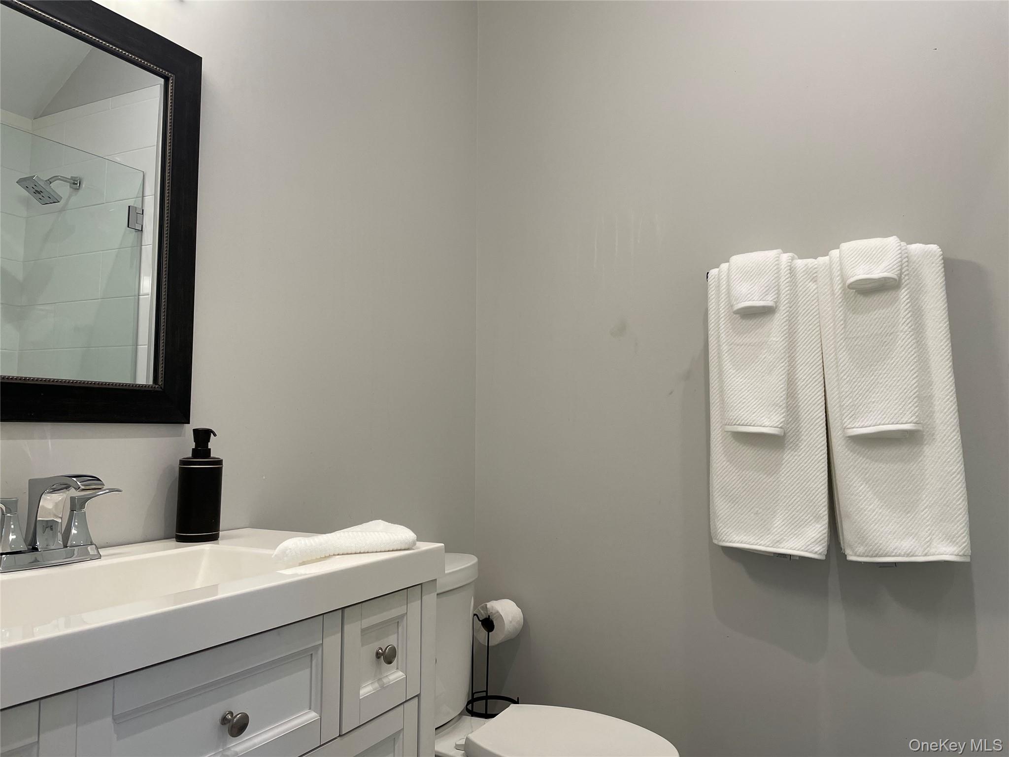 99 Spinney Road East Quogue, NY 11942 - Photo 25 of 40 a bathroom with a granite countertop toilet sink and mirror