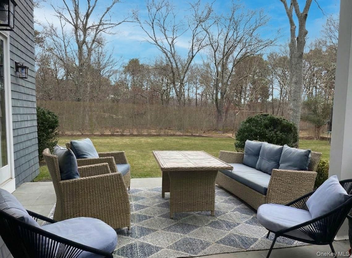 99 Spinney Road East Quogue, NY 11942 - Photo 35 of 40 a view of outdoor sitting area with furniture and wooden fence