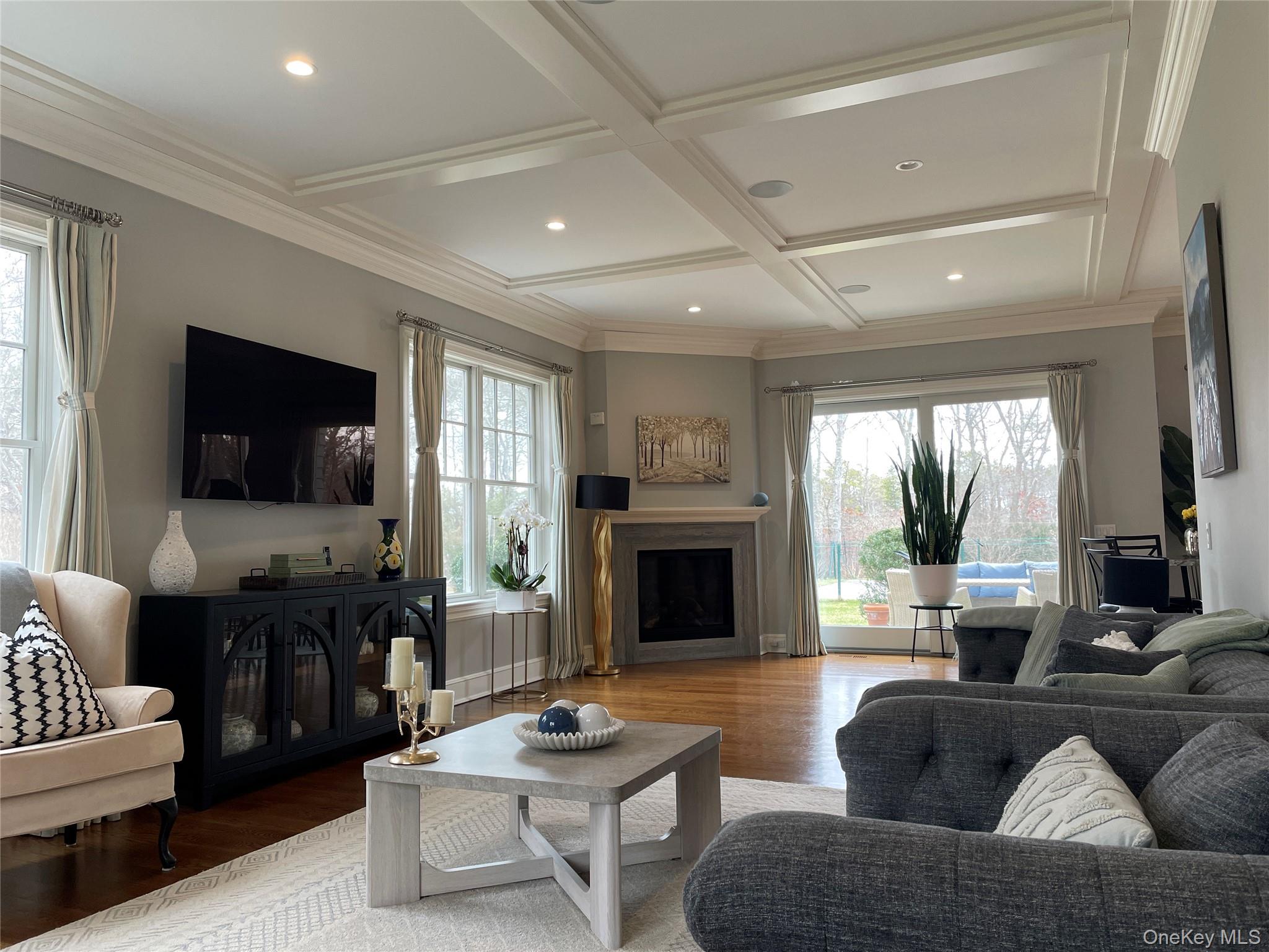 99 Spinney Road East Quogue, NY 11942 - Photo 4 of 40 a living room with furniture flat screen tv and a fireplace