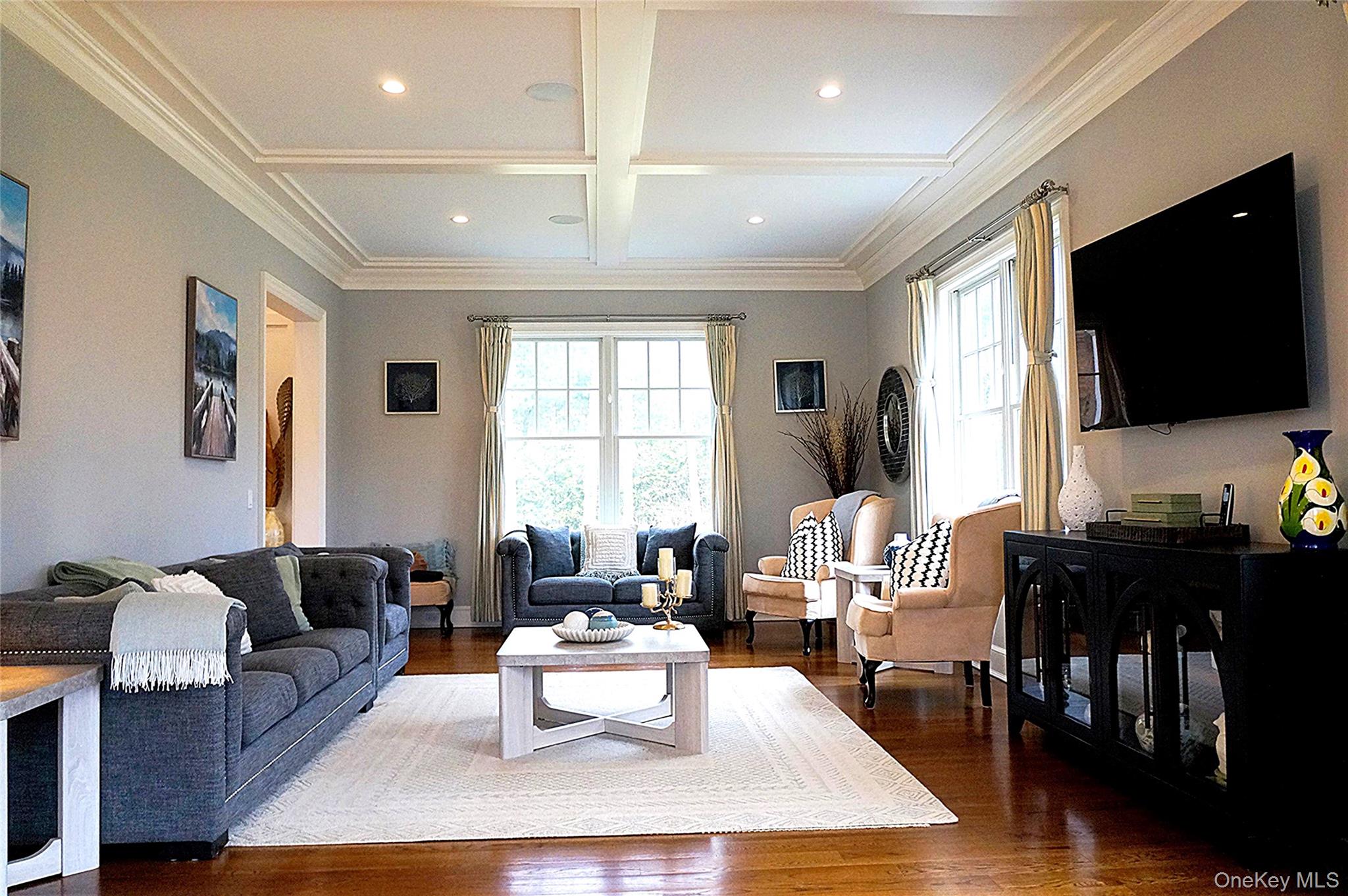 99 Spinney Road East Quogue, NY 11942 - Photo 5 of 40 a living room with furniture a flat screen tv and a large window