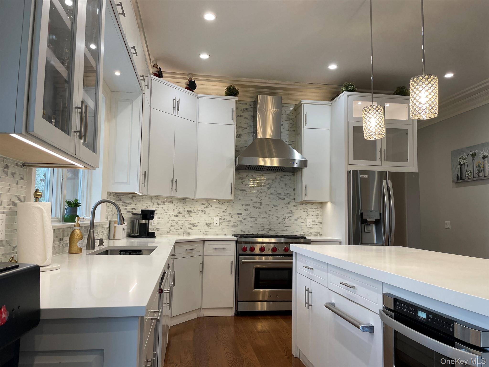 99 Spinney Road East Quogue, NY 11942 - Photo 8 of 40 a kitchen with kitchen island a sink stainless steel appliances and cabinets