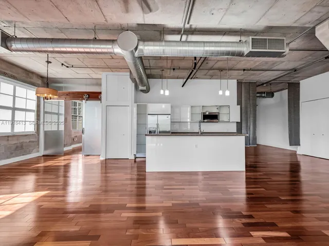 a view of a livingroom with wooden floor and a sink