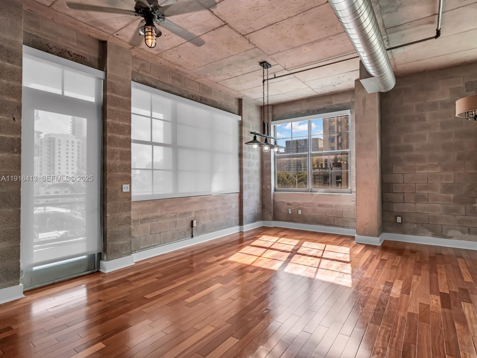 411 Northwest 1st Avenue, Unit 401 Fort Lauderdale, FL 33301 - Photo 18 of 53 a view of an empty room with a window and wooden floor