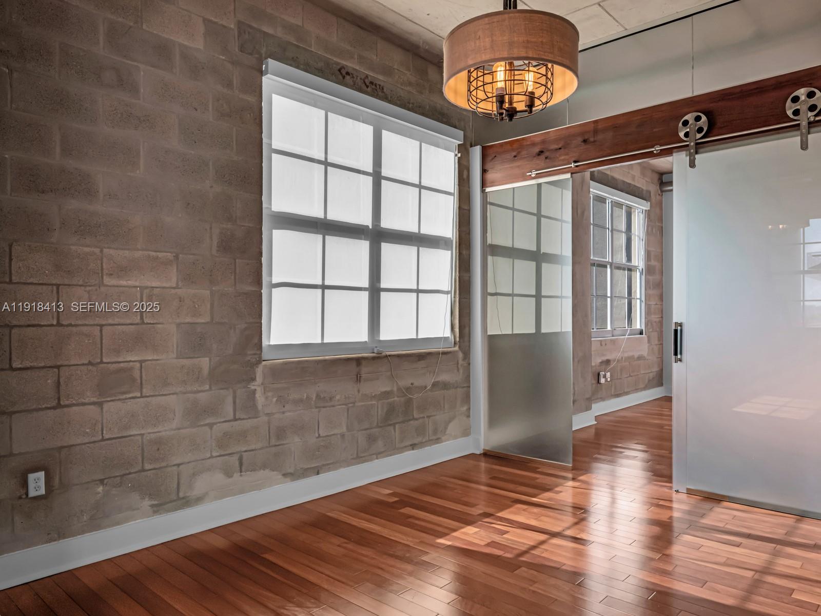 411 Northwest 1st Avenue, Unit 401 Fort Lauderdale, FL 33301 - Photo 19 of 53 a view of an empty room with a window and wooden floor