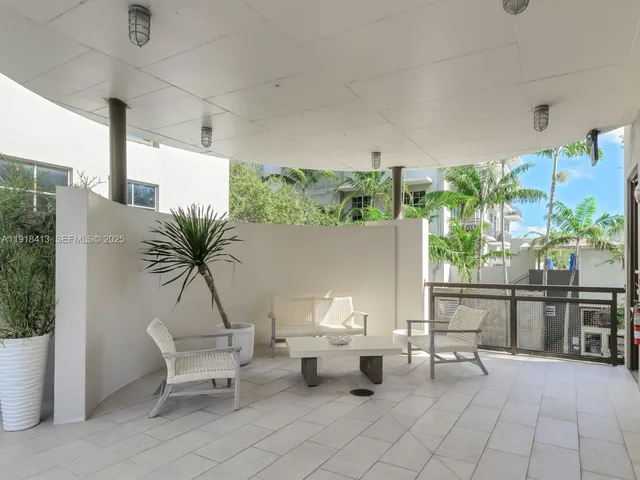a dining room with stainless steel appliances kitchen island granite countertop a table chairs and a refrigerator