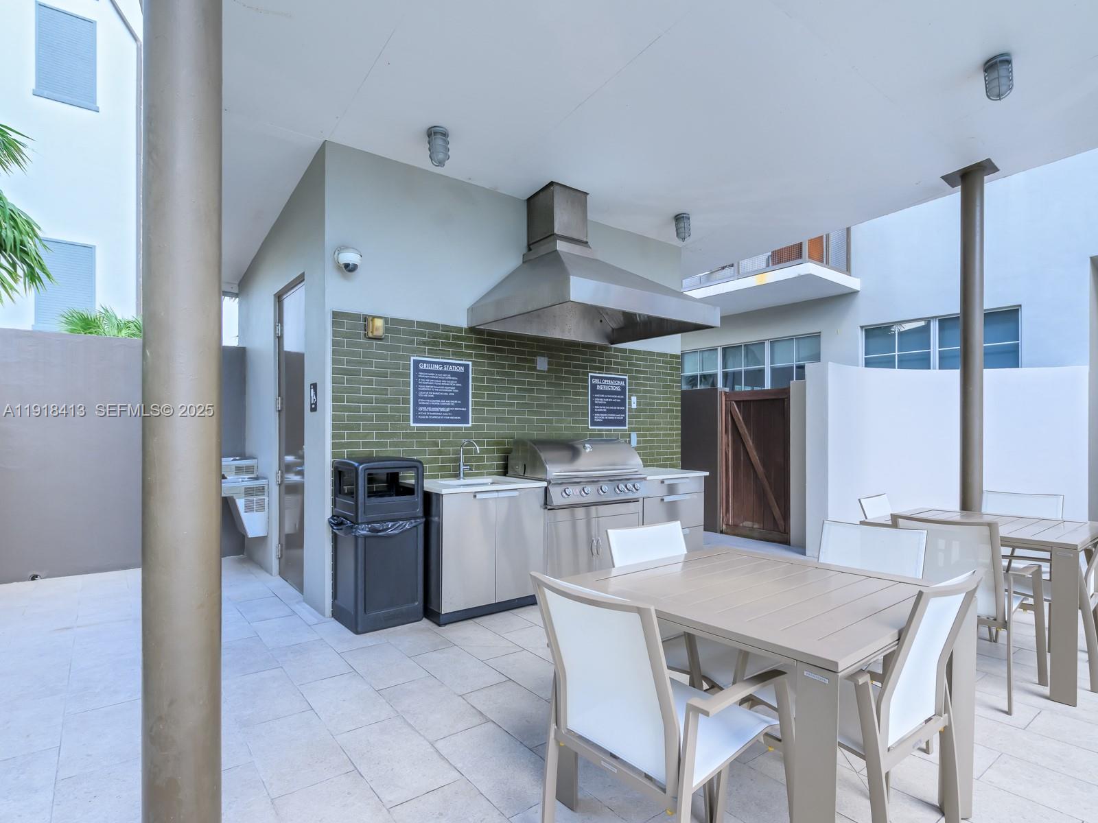 411 Northwest 1st Avenue, Unit 401 Fort Lauderdale, FL 33301 - Photo 42 of 53 a dining room with stainless steel appliances kitchen island granite countertop a table chairs and a refrigerator