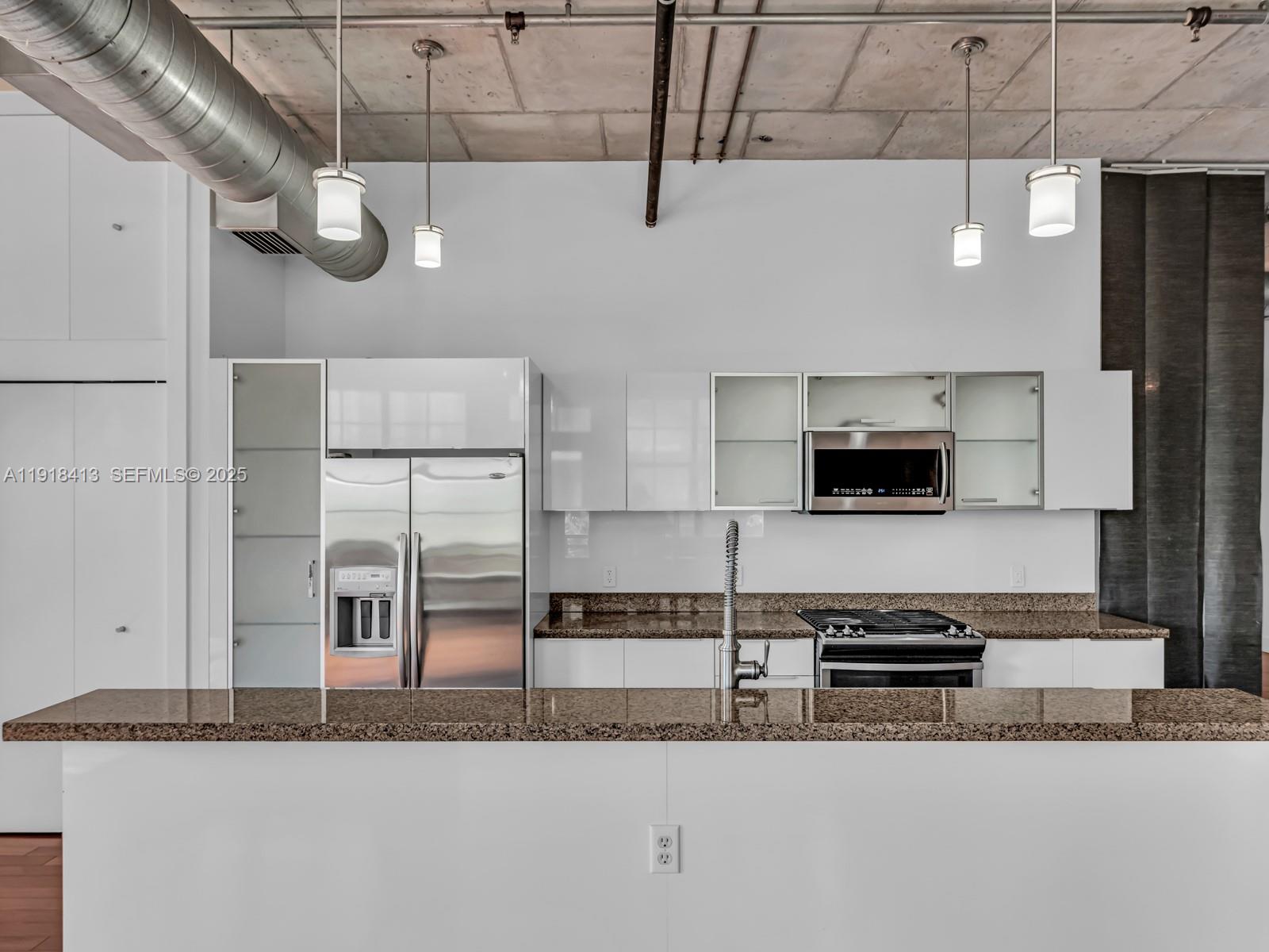 411 Northwest 1st Avenue, Unit 401 Fort Lauderdale, FL 33301 - Photo 9 of 53 a kitchen with stainless steel appliances kitchen island granite countertop a stove a sink and a granite counter tops