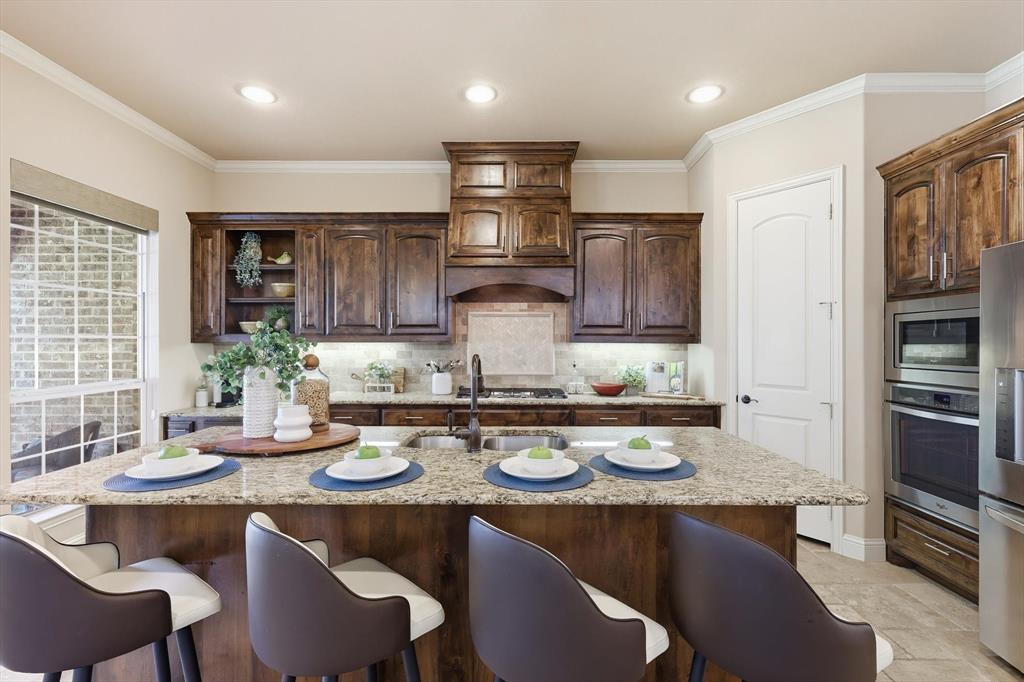617 Two Creeks Plaza Richardson, TX 75080 - Photo 15 of 40 a kitchen with stainless steel appliances granite countertop wooden cabinets stove top oven and granite counter tops