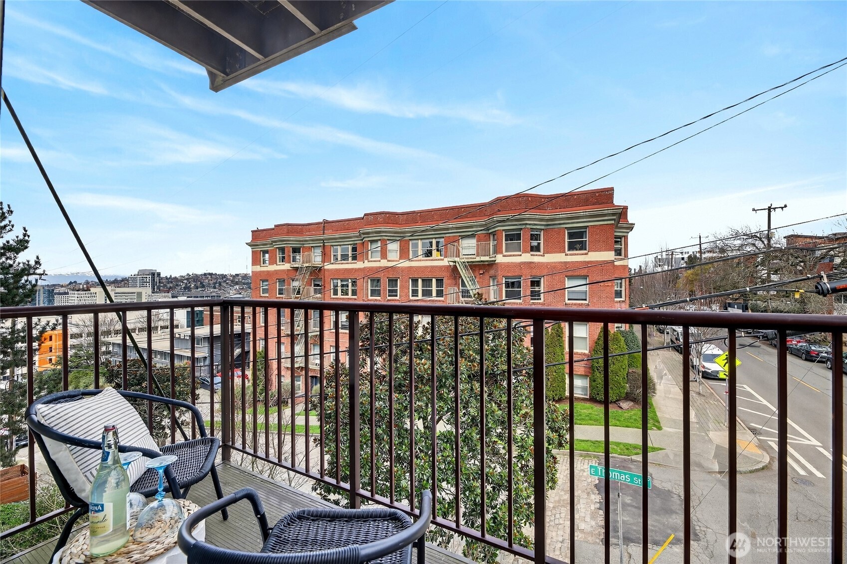 321 East Thomas Street, Unit 303 Seattle, WA 98102 - Photo 16 of 24 a view of a balcony with chairs and wooden floor
