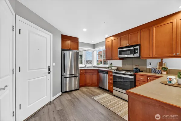a kitchen with stainless steel appliances granite countertop a refrigerator stove top oven and sink