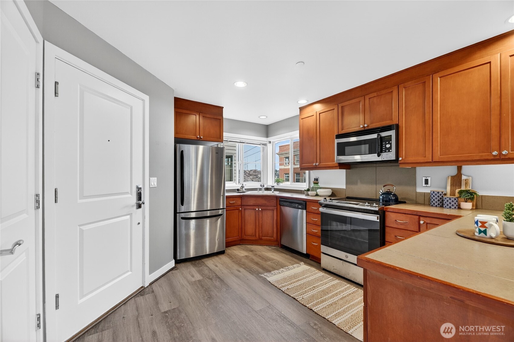 321 East Thomas Street, Unit 303 Seattle, WA 98102 - Photo 4 of 24 a kitchen with stainless steel appliances granite countertop a refrigerator stove top oven and sink