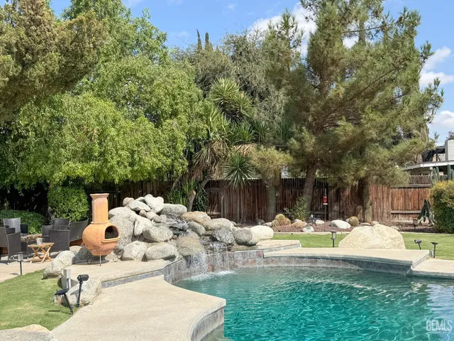 a view of a patio with a table and chairs under an umbrella with potted plants