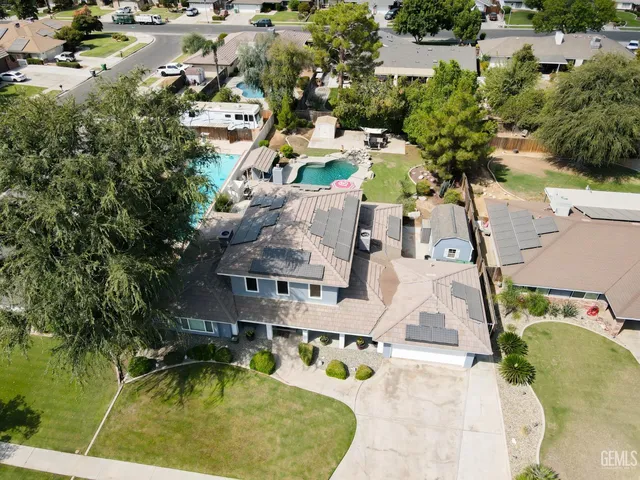 an aerial view of residential houses with outdoor space and swimming pool