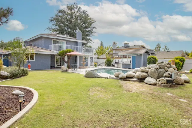 a view of a patio with a dining table and chairs under an umbrella with a sink
