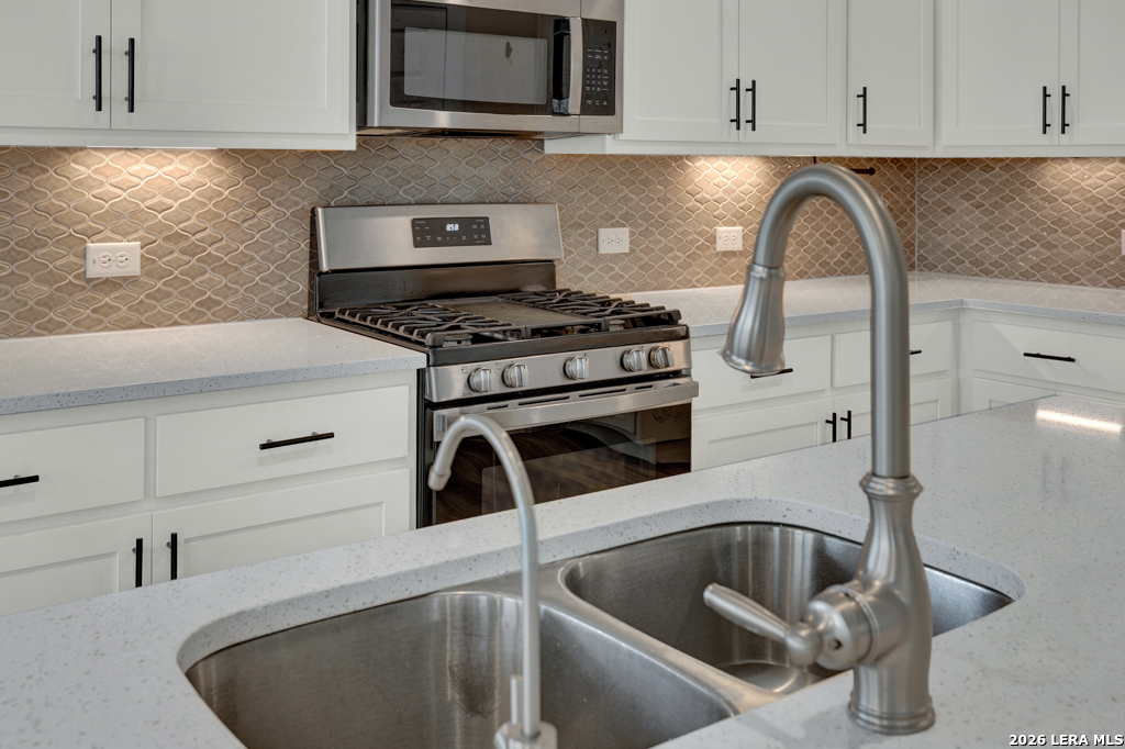 1433 Escarpment Road New Braunfels, TX 78132 - Photo 12 of 37 a kitchen with a stove and a white cabinet