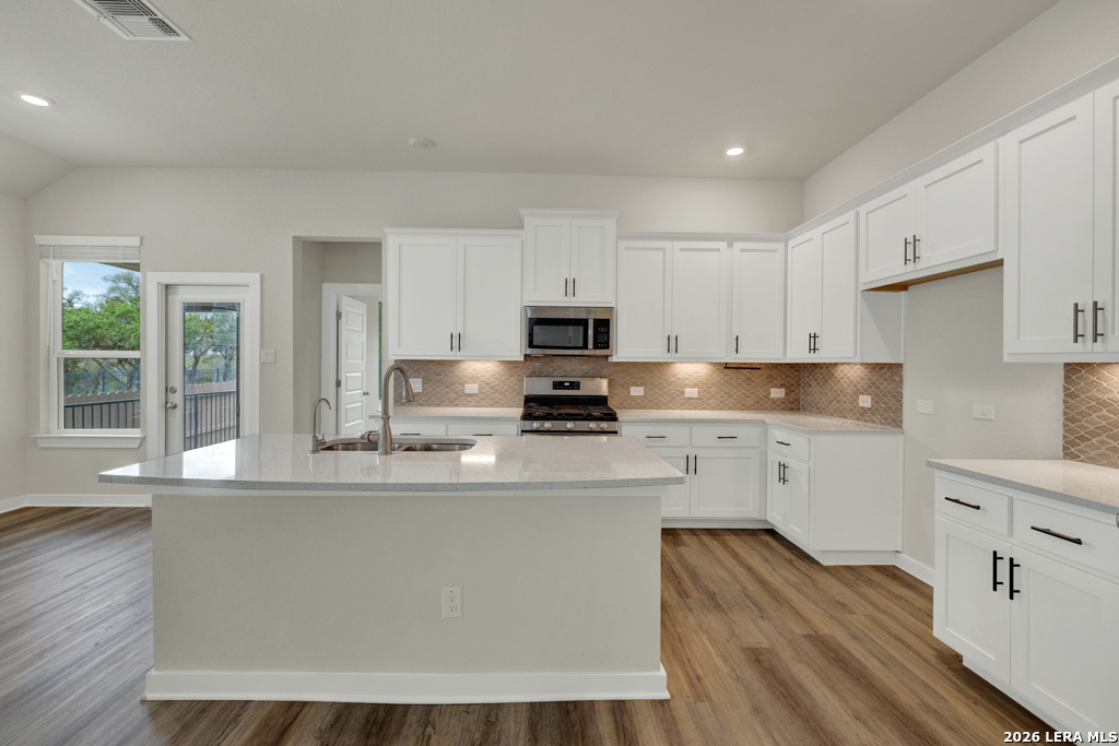 1433 Escarpment Road New Braunfels, TX 78132 - Photo 15 of 37 a kitchen with stainless steel appliances granite countertop a stove a sink and a microwave