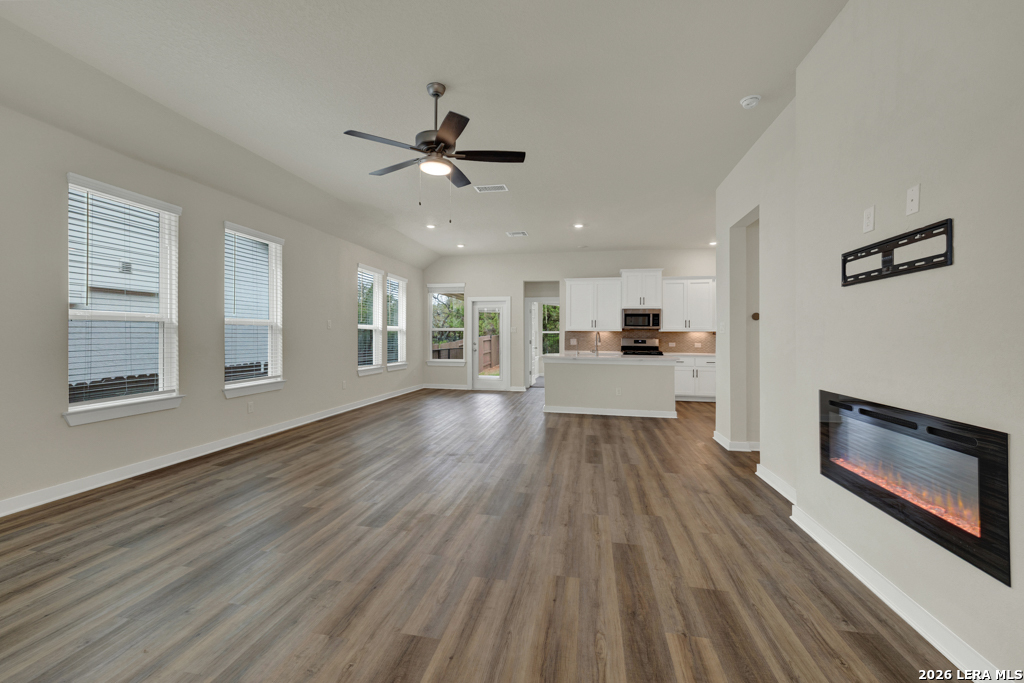 1433 Escarpment Road New Braunfels, TX 78132 - Photo 6 of 37 a view of a living room with wooden floor a ceiling fan and windows