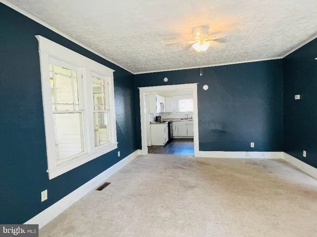 an empty room with a kitchen and a window