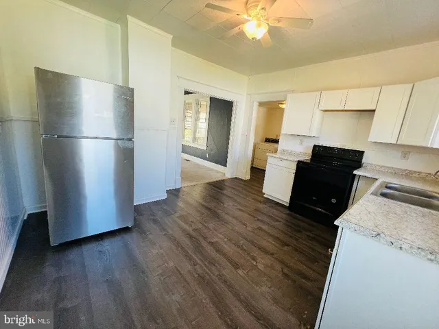 a kitchen with a refrigerator and a stove top oven