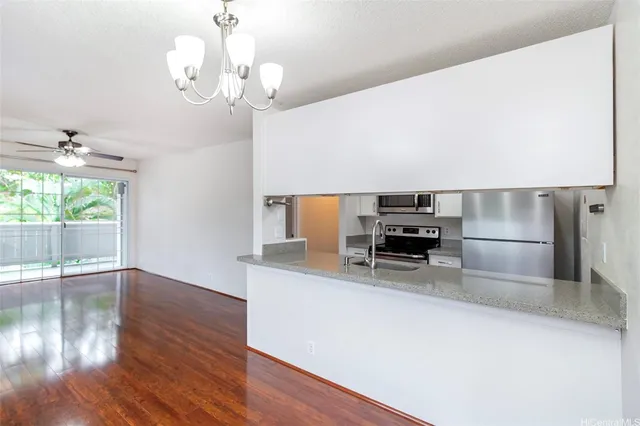a kitchen with granite countertop a oven a stove and a wooden floors