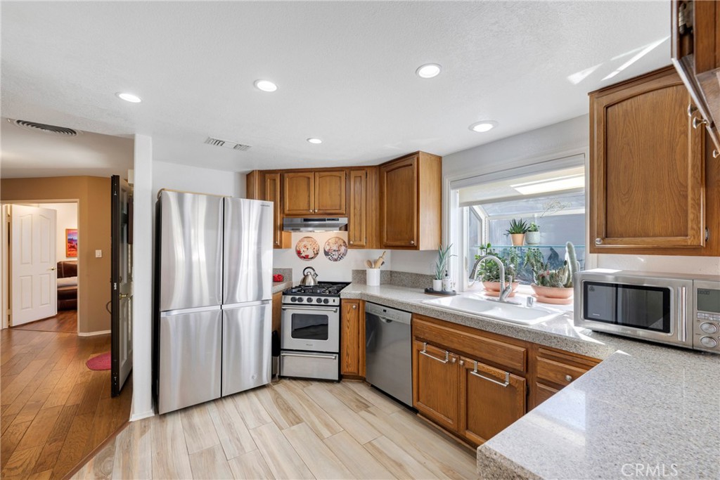 40370 Vía Francisco Murrieta, CA 92562 - Photo 12 of 52 a kitchen with a refrigerator sink and wooden floor