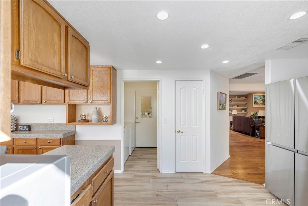 40370 Vía Francisco Murrieta, CA 92562 - Photo 13 of 52 a view of a kitchen with kitchen island granite countertop wooden cabinets and a refrigerator