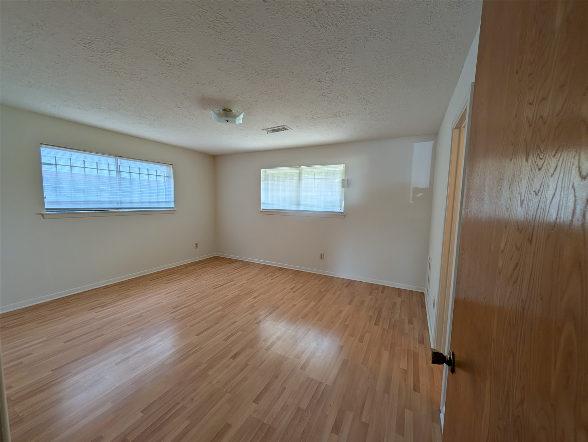 322 Ravenhead Drive Houston, TX 77034 - Photo 5 of 16 an empty room with wooden floor and windows