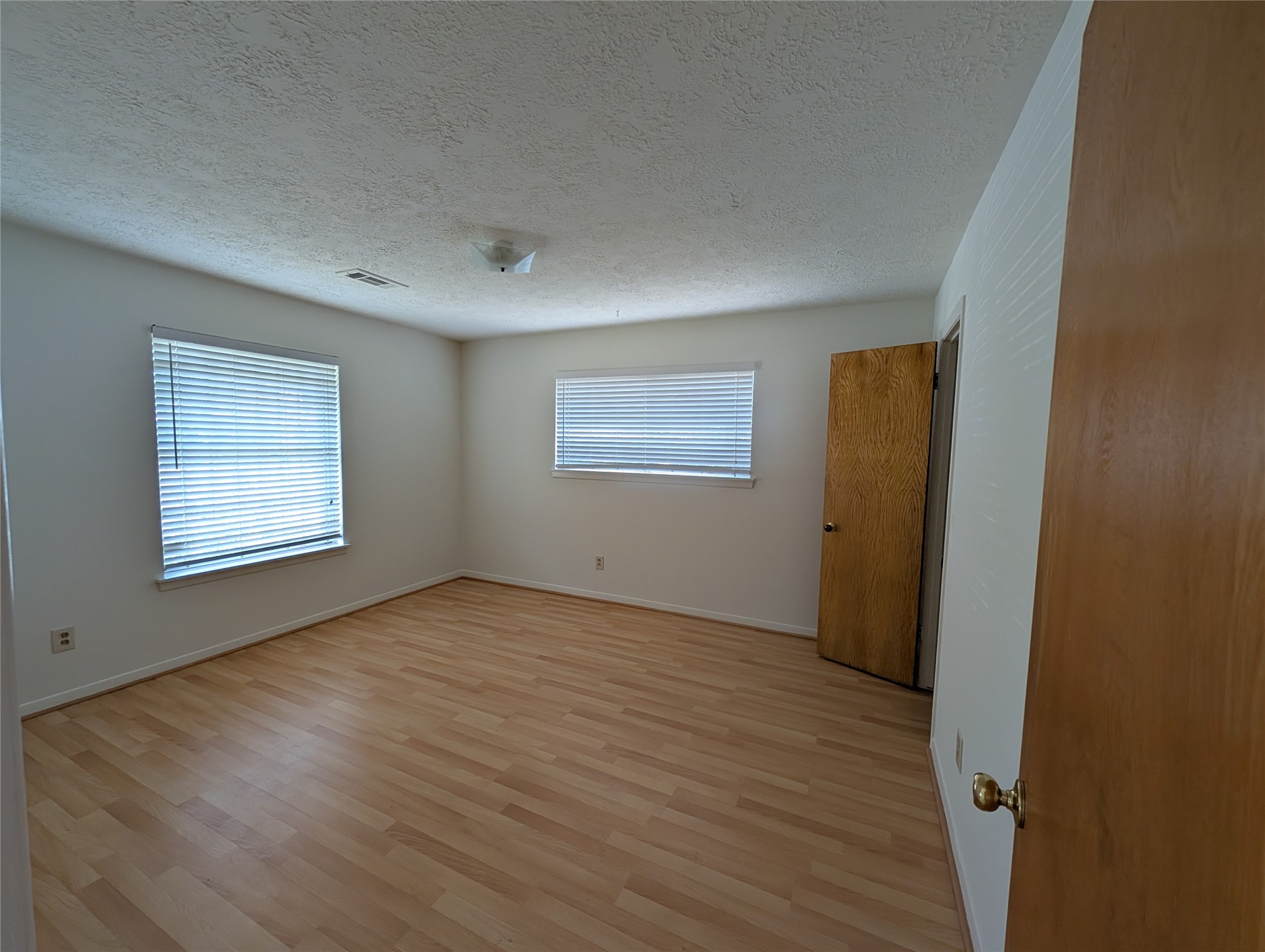 322 Ravenhead Drive Houston, TX 77034 - Photo 7 of 16 a view of an empty room with wooden floor and a window